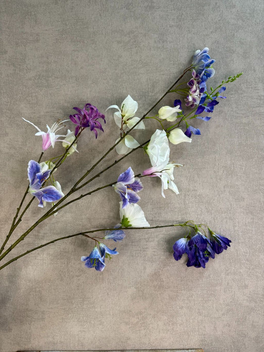 Extra lange kunstbloem met gemengde bloemen in wit, blauw en paars, liggend op een neutrale achtergrond.