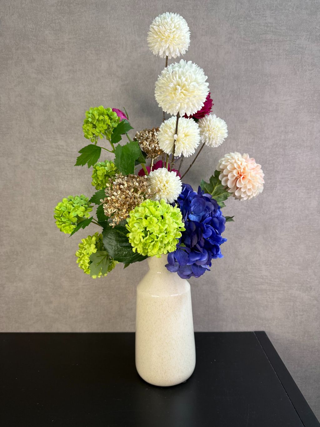 Kunstboeket Liz met bontgekleurde kunstbloemen in een lichte vaas, kleurrijk en speels geschikt als blikvanger.