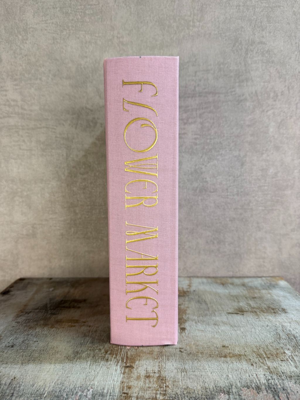 Roze opbergboek Flower Market met bloemenillustratie en gouden tekst, staand op een houten ondergrond.