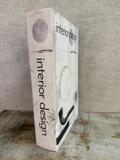Beige opbergboek van Homebound met zwarte Interior design-print en een bruin opbergvak aan de binnenzijde.
