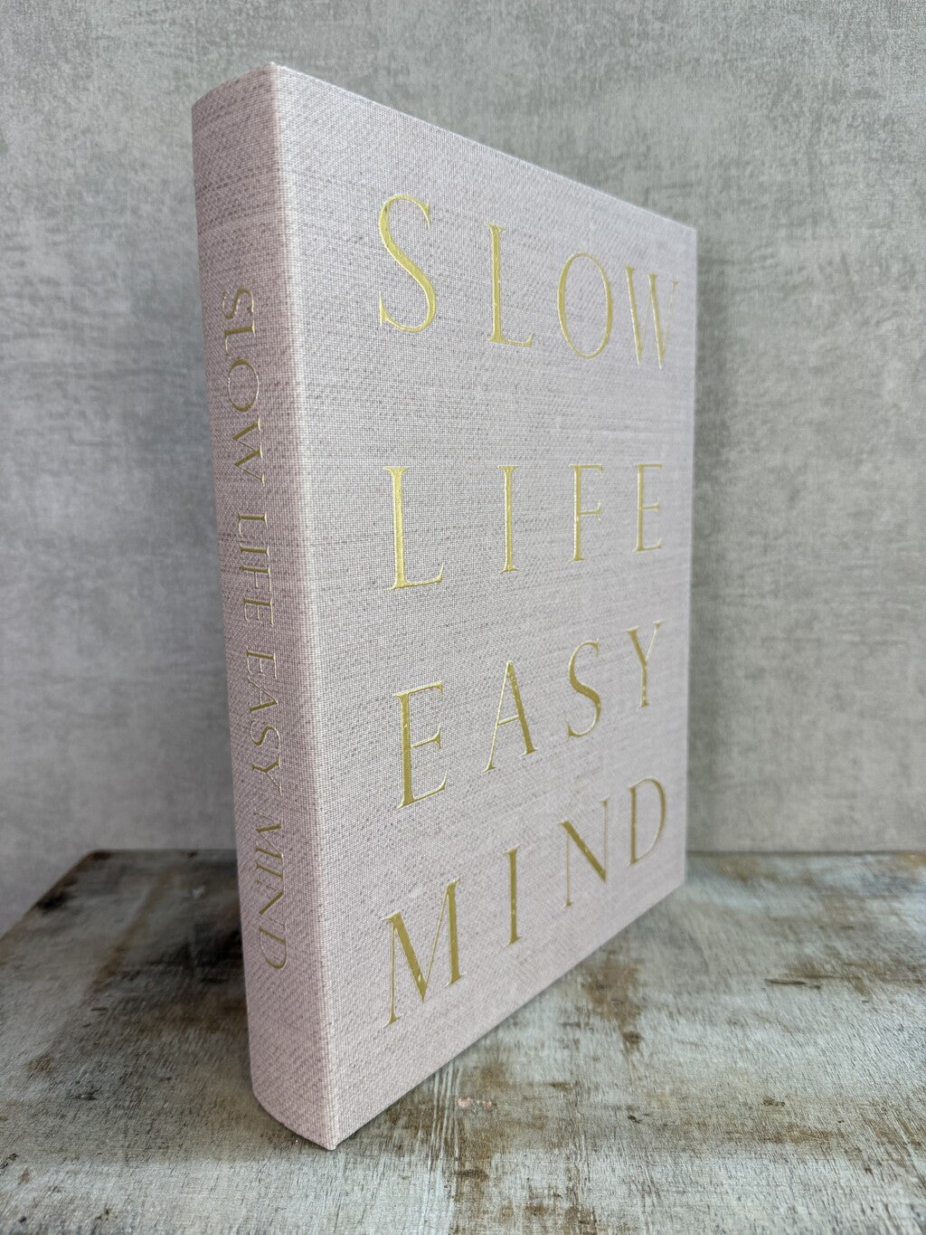 Beige opbergboek van Homebound met goudkleurige tekst Slow Life Easy Mind en een bruin opbergvak aan de binnenzijde.