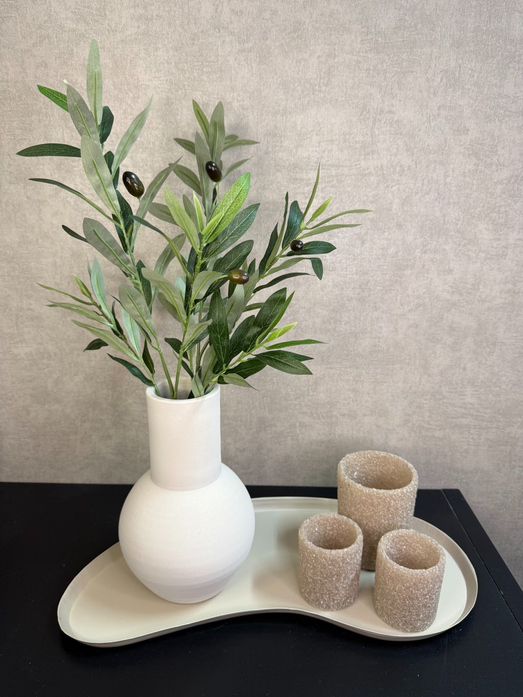 Organisch gevormd beige metalen dienblad met moderne kidney-vorm met accessoires.