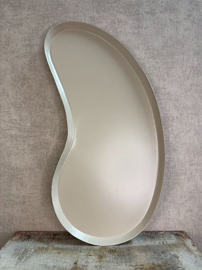 Organisch gevormd beige metalen dienblad met moderne kidney-vorm.