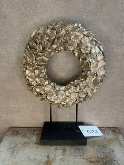Ornament Krans glitter champagne – ronde decoratie met glanzende bladeren op zwarte standaard van Eglo Living.