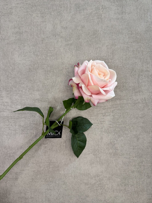 Roze real touch kunstroos van Mica met groene steel en bladeren op een grijze achtergrond.