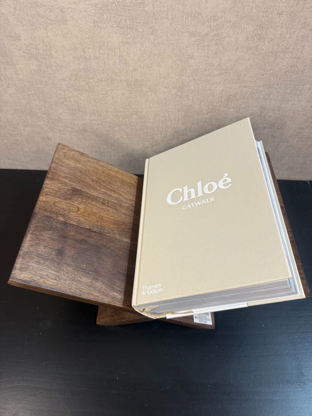 Beige hardcover tafelboek ‘Chloé Catwalk – The Complete 69’ op houten ondergrond, decoratief en stijlvol voor interieur of fashioncollectie.