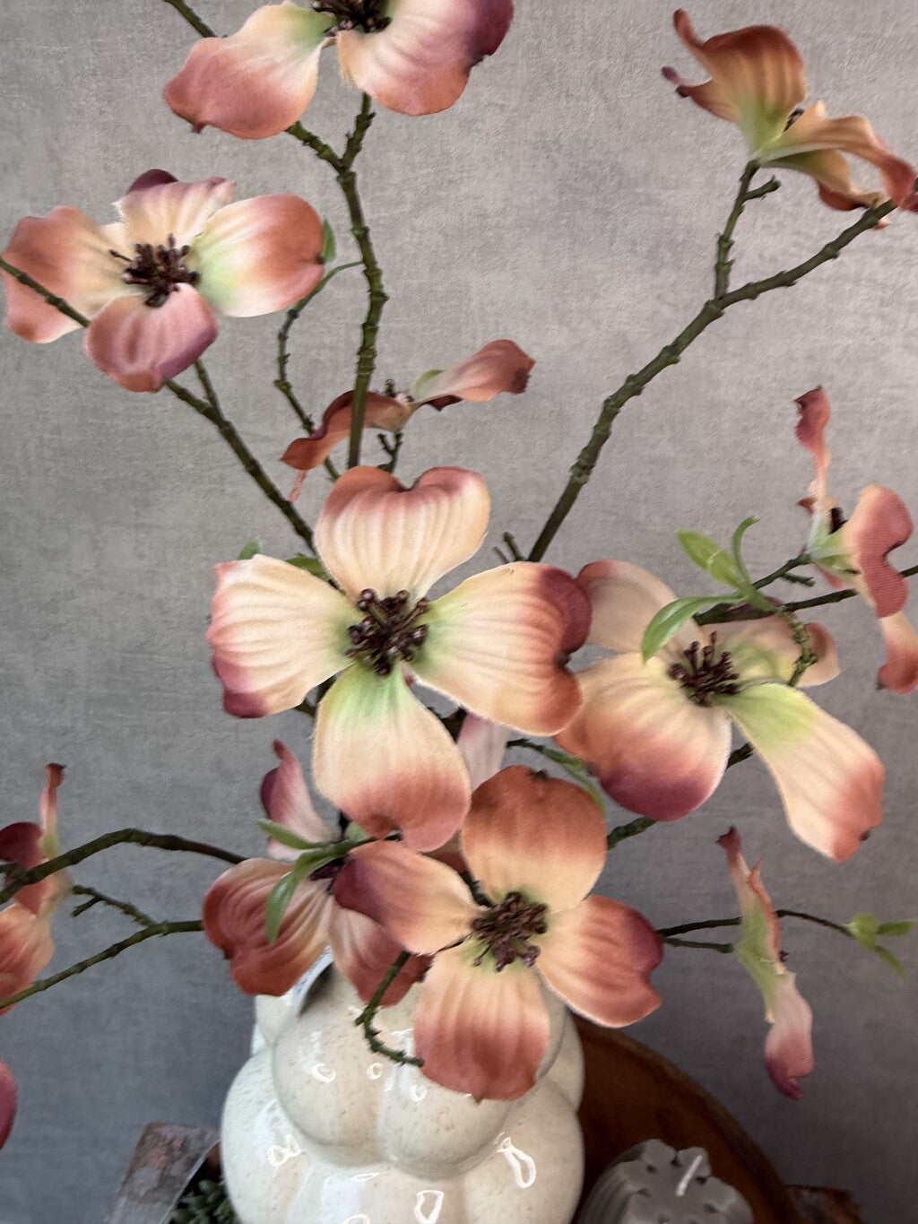 Tafel decoratie set Livara met houten dienblad, beige vaas, kleurrijke kunstbloemen, groene hangplant en decoratieve kaarsen.