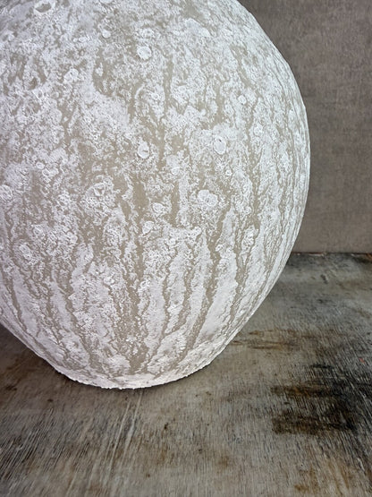 Beige keramieken kruikvaas met ronde vorm en twee decoratieve oren op een houten ondergrond.