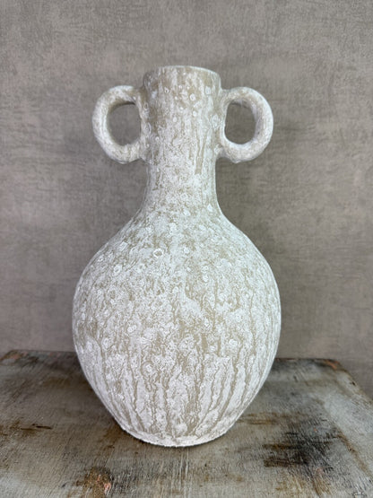 Beige keramieken kruikvaas met ronde vorm en twee decoratieve oren op een houten ondergrond.