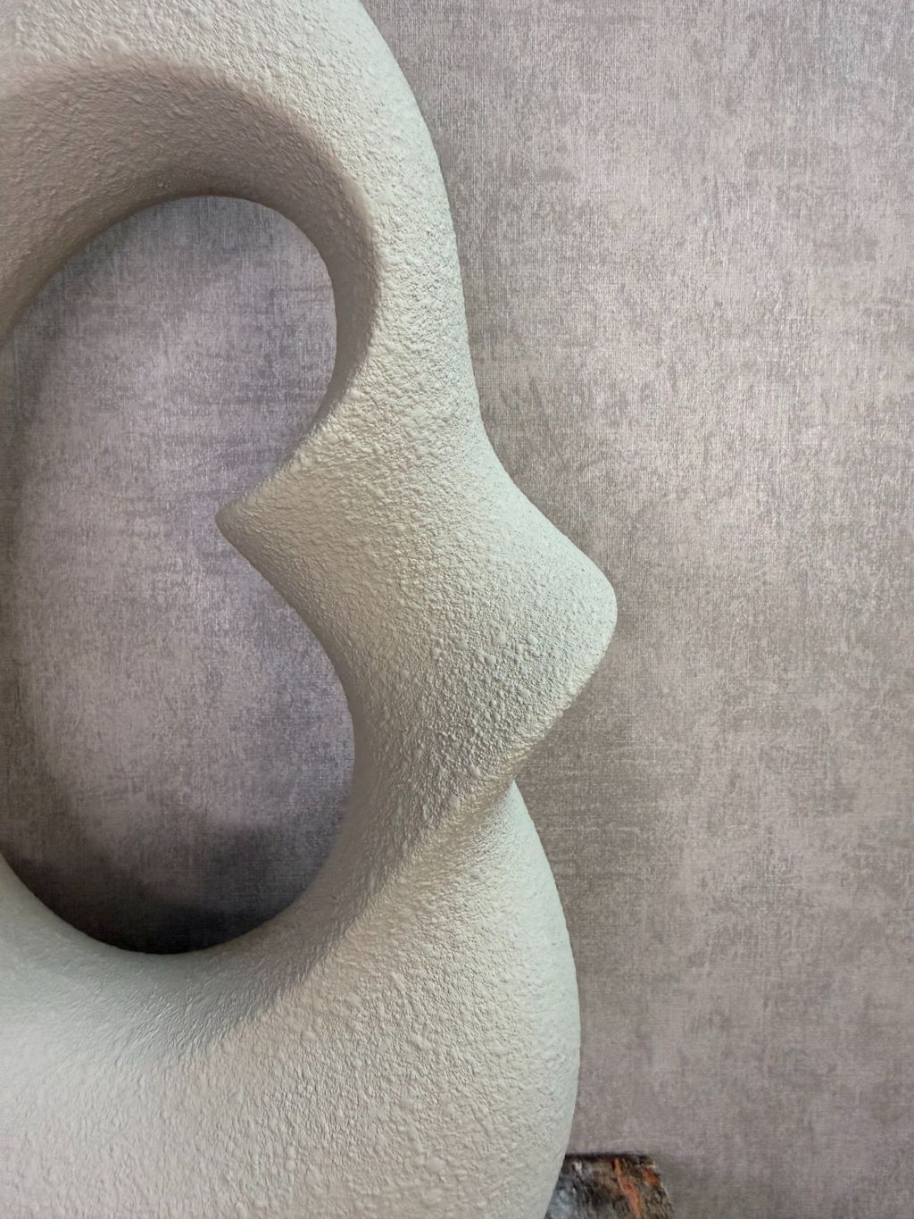 Set van twee beige keramieken vazen met organische open vorm in verschillende formaten op een houten ondergrond.