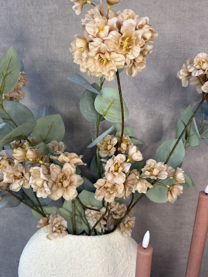 Vensterbank decoratie set Rena met beige vaas, roze kunstbloemen, groene takken en twee beige kandelaars.