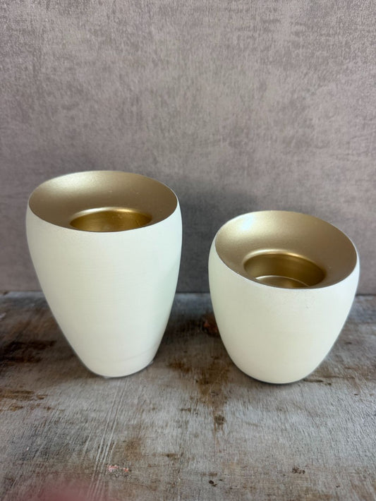 Twee waxinelichthouders Veroli in crème met gouden binnenzijde van Light & Living, in groot en klein formaat op houten oppervlak.