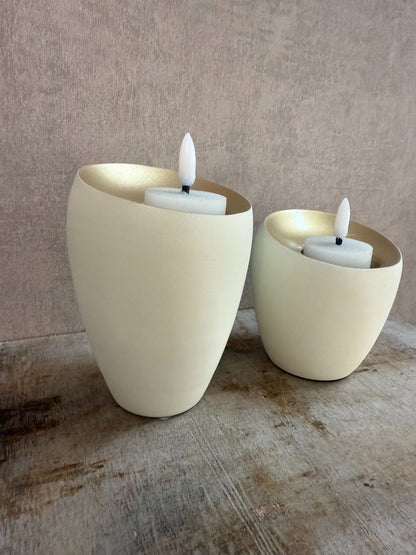 Twee waxinelichthouders Veroli in crème met gouden binnenzijde van Light & Living, in groot en klein formaat op houten oppervlak.